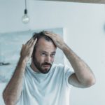 Middle,Aged,Man,With,Alopecia,Looking,At,Mirror,,Hair,Loss