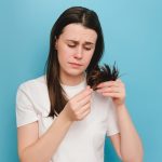 Unhappy,Young,Woman,Brushing,Looking,At,Split,Ends,,Isolated,Over